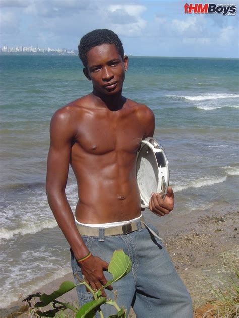 skinny black gay model on the beach for a striptease and