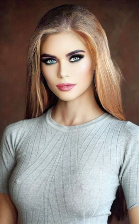 a barbie doll with blonde hair and blue eyes wearing a gray sweater