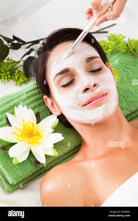 cosmetician applying facial beauty mask  young woman  spa salon