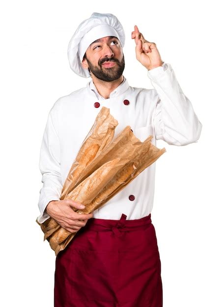 young baker holding  bread    fingers crossing photo