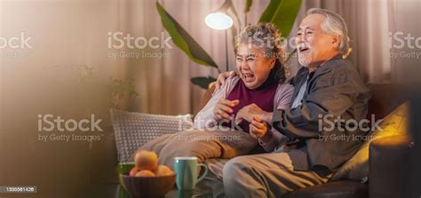old retired age asian couple watching tv at homeold mature asian couple