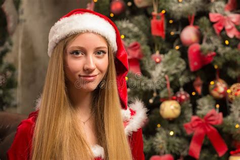 beautiful model dressed as santa with near a christmas tree stock image