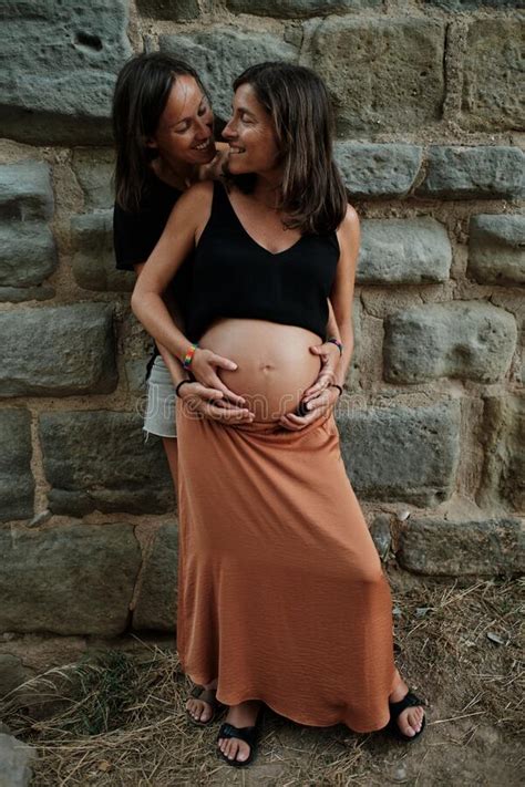 Vertical Closeup Of A Pregnant Lesbian Couple Doing A Photoshoot In A
