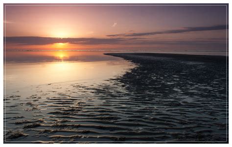 sun  setting   water   beach  ripples   sand