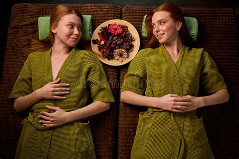 Two Redhead Ladies Lie On Bed Relaxing After Spa Treatment Massage