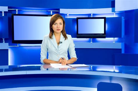 news anchor sitting   desk  front   televisions