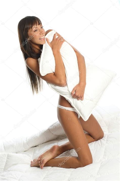 chica atractiva desnuda de rodillas en la cama y abrazando la almohada — foto de stock