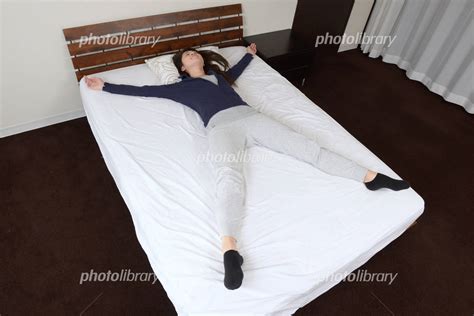 大の字になって寝る若い女性 写真素材 [ 3267356 ] フォトライブラリー photolibrary