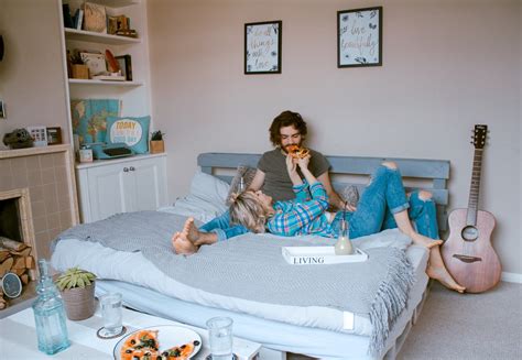 Free Photo Couple Feeding Each Other In Bed With Pizza