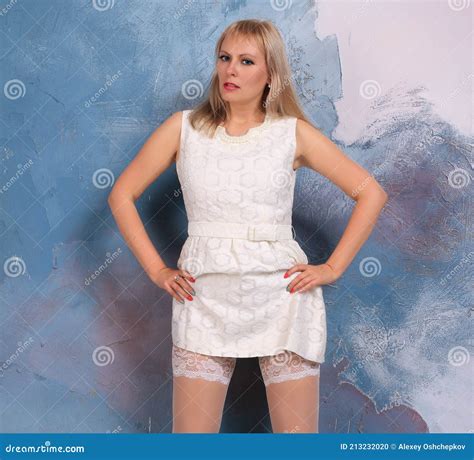 Blonde Legged Photomodel In White Minidress And White Stockings Posing