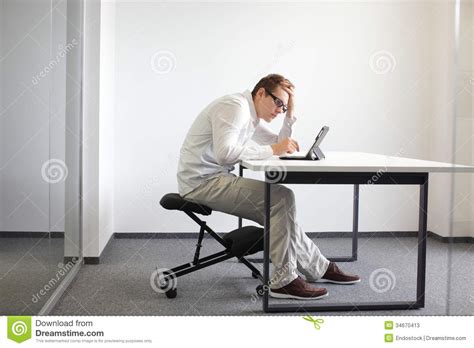 young man  bent   tabletbad sitting posture  work stock