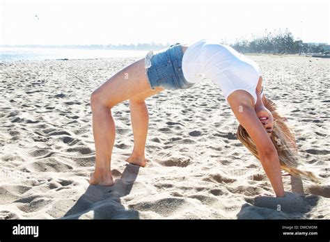 Young Woman Bending Over Backwards On Beach Melbourne Victoria