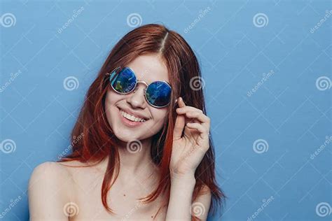 mujer pelirroja perky con lentes azules hombros desnudos posando foto
