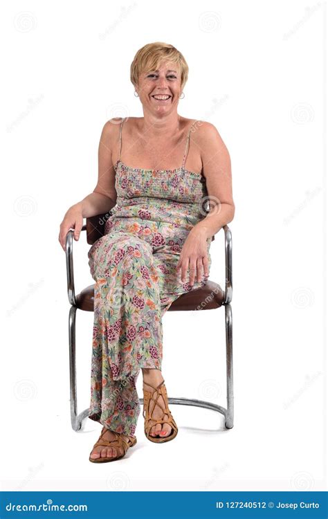 Full Portrait Of Middle Aged Woman Sitting On A Vintage Chair On Stock