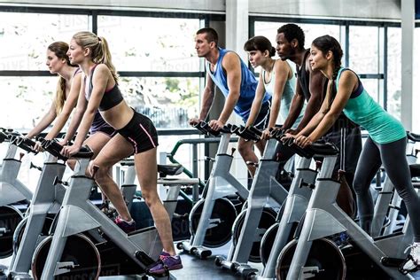 Fit People Working Out At Spinning Class In The Gym