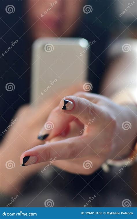 The Brunette Girl Takes Pictures Of Her Two Fingers On A Modern Stock
