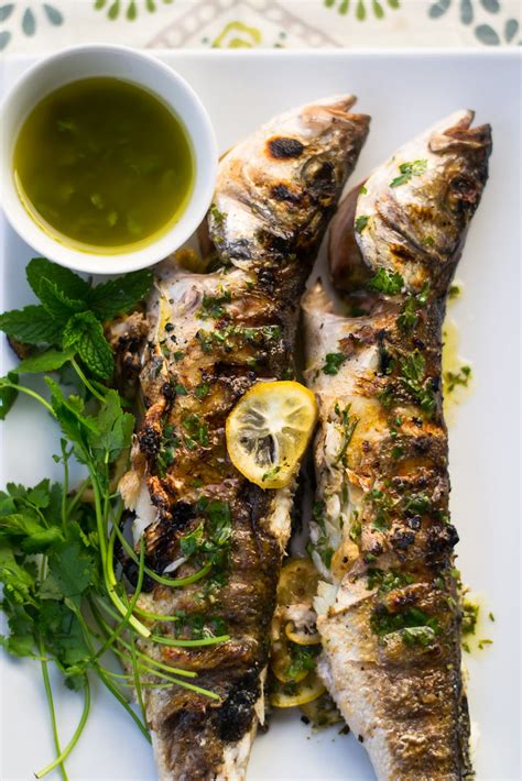 Grilled Branzino With Lemon Slices Fresh Herbs And Citrus Olive Oil