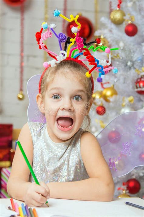 girl with a toy fireworks on the head draws a congratulatory new years