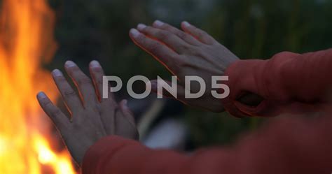 Young Female Hiker Warming Up Her Hands By A Fire Stock Footage Ad