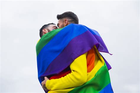 photo gays hugging  covering rainbow flag