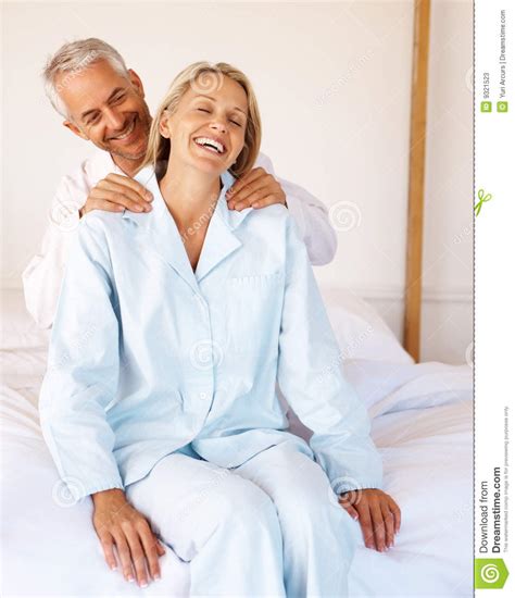 mature man giving a shoulder massage to his wife stock