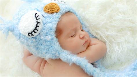 cute newborn baby  sleeping  white woolen bed wearing knitted