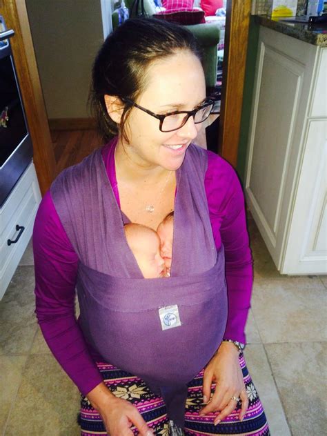 a pregnant woman wearing glasses standing in a kitchen