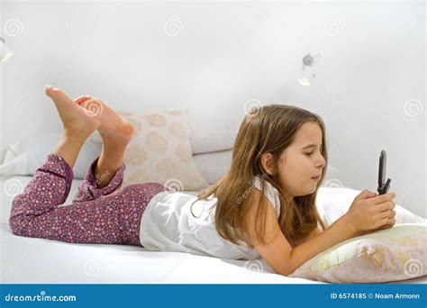 meisje dat op bed met celtelefoon ligt stock afbeelding image  bespreking meisje