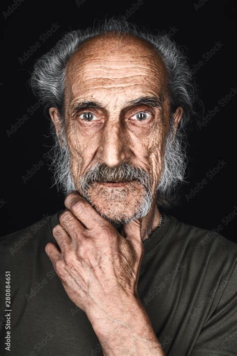 Thin Mad Skinny Old Man In Green T Shirt With A Palm On The Chin