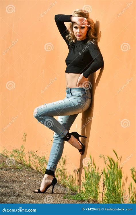 Glamour Fashion Model With Perfect Slim Body Posing Outside At The Wall