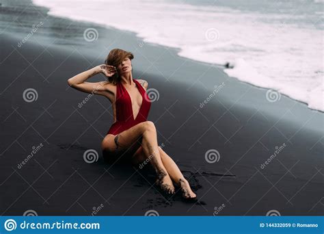 jong sexy meisje met grote borsten in een rood zwempak die