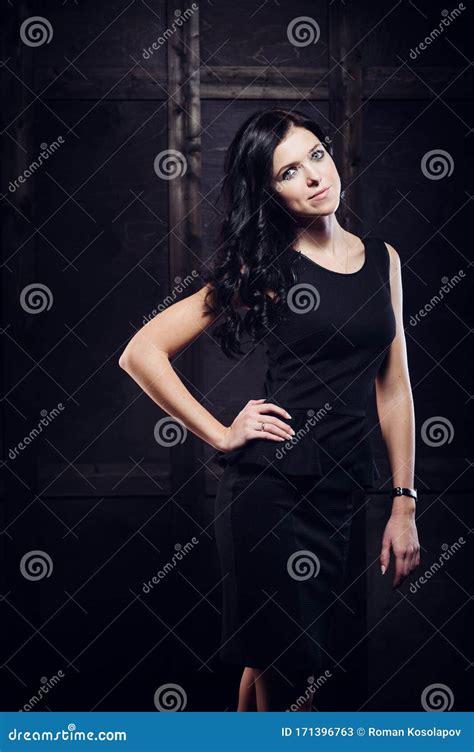 vacker kvinna i sexig kvällsklänning mot mörk bakgrund fotografering