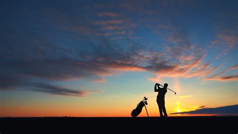 man golf player hit ball to air silhouetted in sunset golf