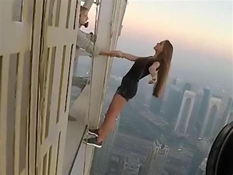a woman has risked her life dangling off a building for a