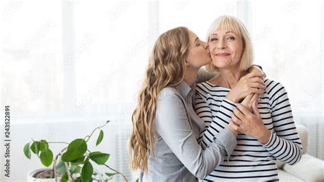 Young Daughter Kissing Senior Mother On The Cheek Foto De Stock Adobe