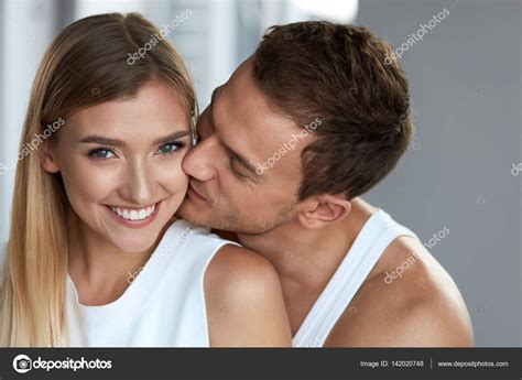 Portrait Of Handsome Man Kissing Happy Woman With Soft Face Skin Stock