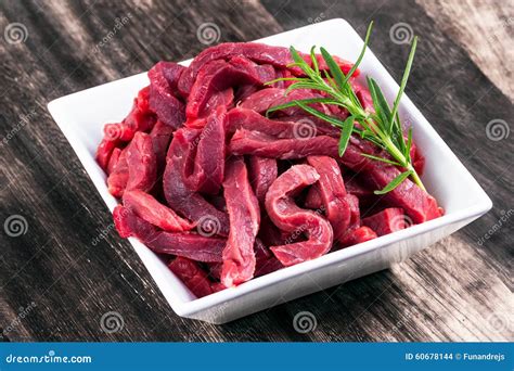 fresh uncocked beef sliced meat rosemary stock photo image  butcher board