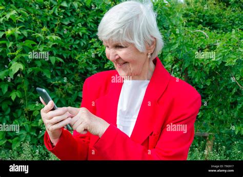 Portrait Of Old Lady Grandmother Makes Selfie Outdoors At Sun Day
