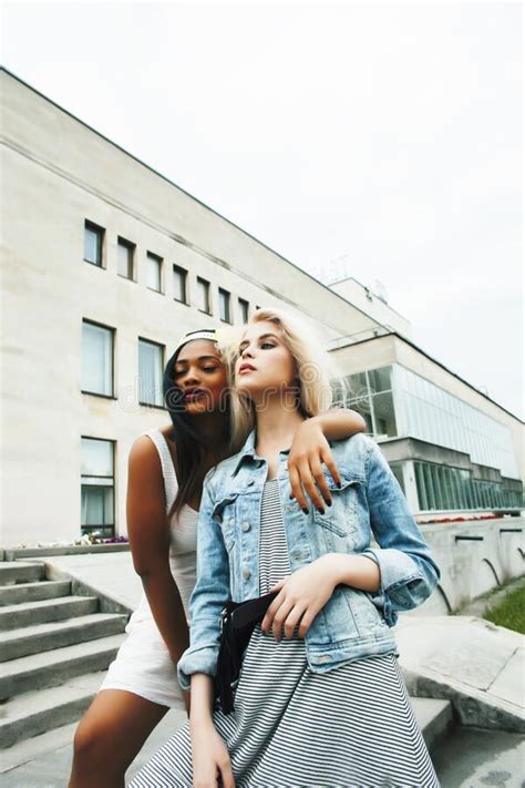 two teenage diverse nations girls infront of university building