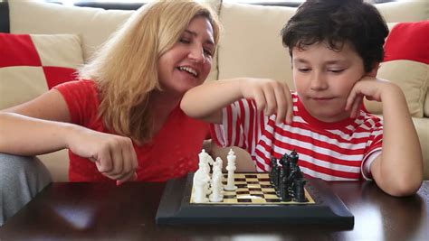 mother teaches son how to play chess stock footage video