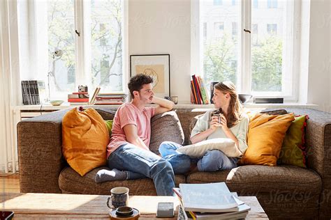 young couple talking  sitting  sofa  home  stocksy
