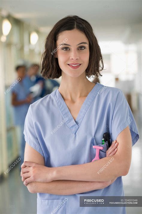 portrait  smiling female nurse standing  arms crossed caucasian