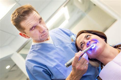 female patient at dentis teeth whitening procedure stock