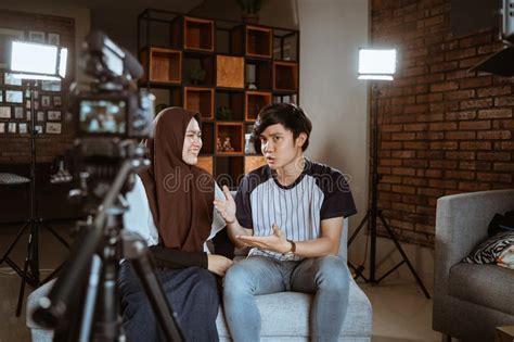Asian Muslim Couple Blogger Recording Vlog Talking To Camera Stock