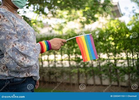 asian lady holding rainbow color flag symbol of lgbt pride month