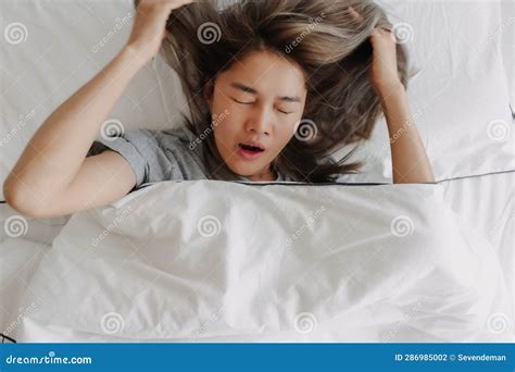 Top View Of Yawning And Stretching Woman Just Wake Up On The Bed Stock