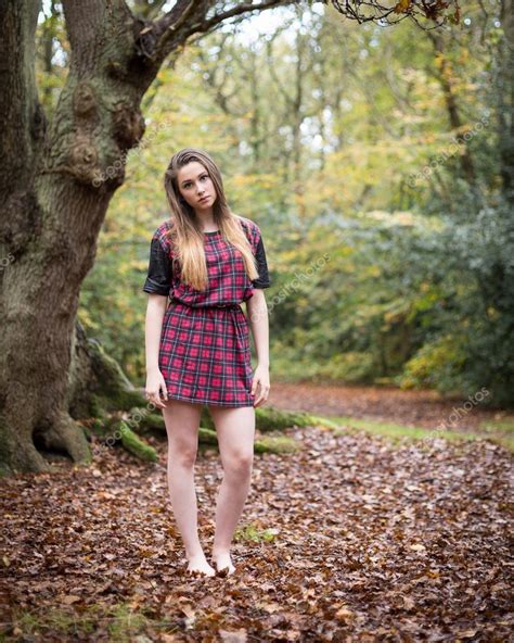 portrait of a beautiful teenage girl standing in a forest