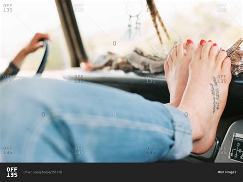 feet of woman resting her feet on the dashboard of a vehicle stock