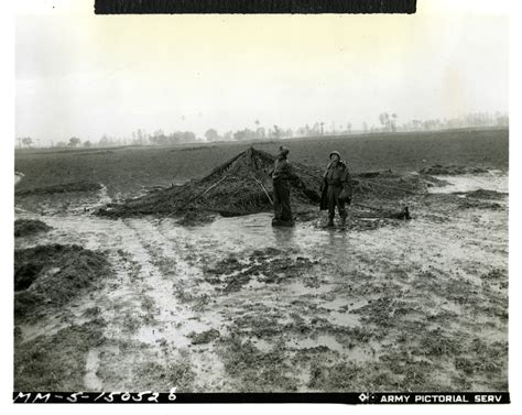 soldiers standing   muddy rain soaked field  italy