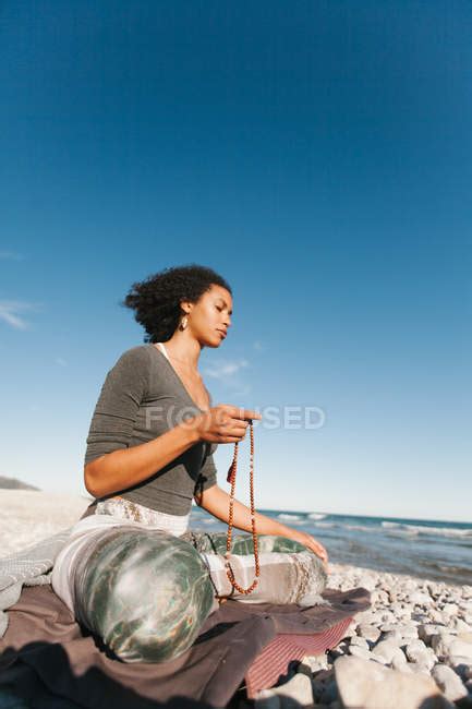 attractive young woman meditating  praying wearing japamala collar